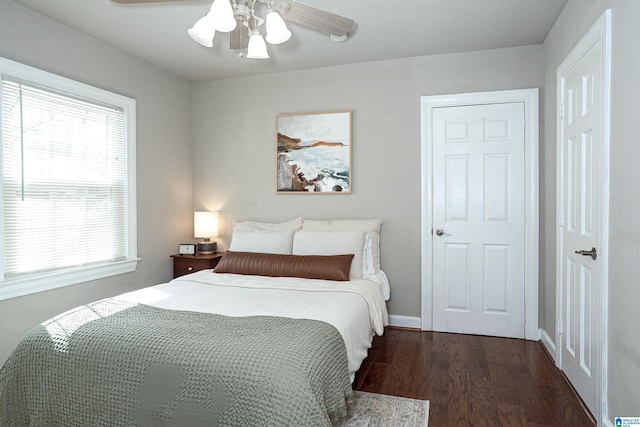 bedroom with baseboards, wood finished floors, and a ceiling fan