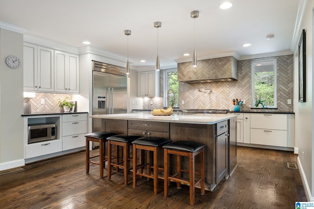 5448 Palomino Trl, Birmingham, AL 35242 - kitchen with a kitchen bar, a kitchen island, stainless steel appliances, decorative backsplash, and dark wood-style floors
