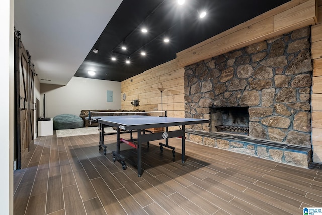 5448 Palomino Trl, Birmingham, AL 35242 - rec room with wood walls, a fireplace, a barn door, and wood finished floors