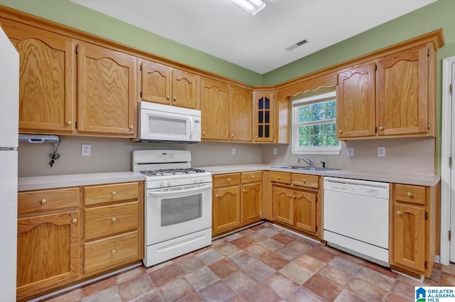 kitchen featuring white appliances, stone finish flooring, visible vents, light countertops, and a sink