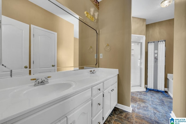 bathroom with a sink, baseboards, double vanity, and a stall shower