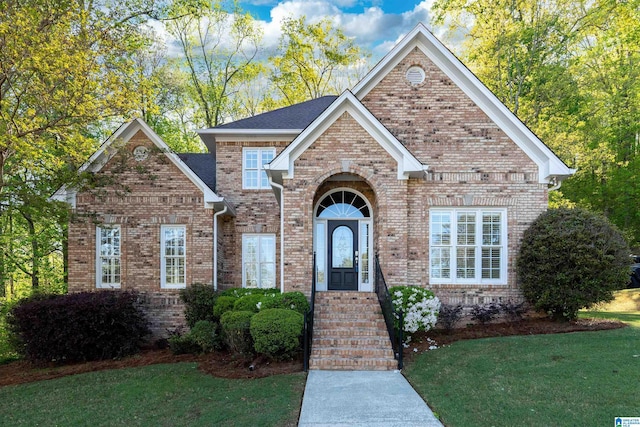 view of front of house with a front yard and brick siding