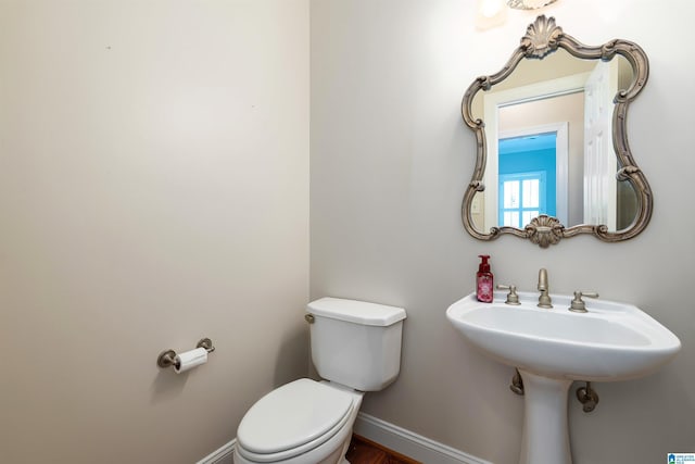 bathroom featuring toilet and baseboards