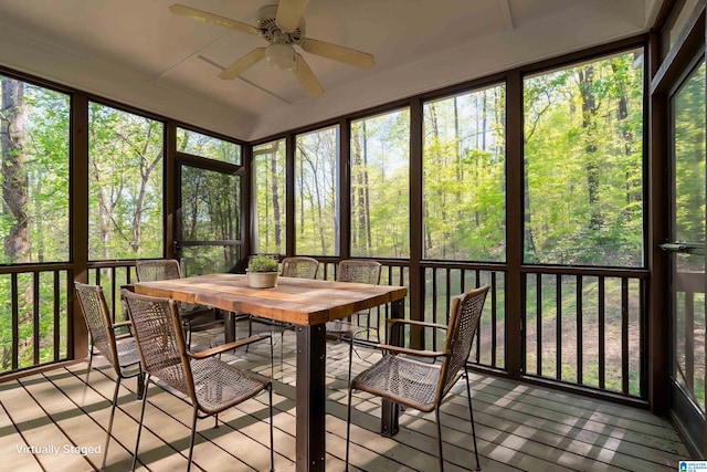 sunroom / solarium featuring outdoor dining area and ceiling fan
