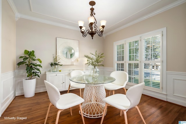 dining space with wainscoting, wood finished floors, and crown molding