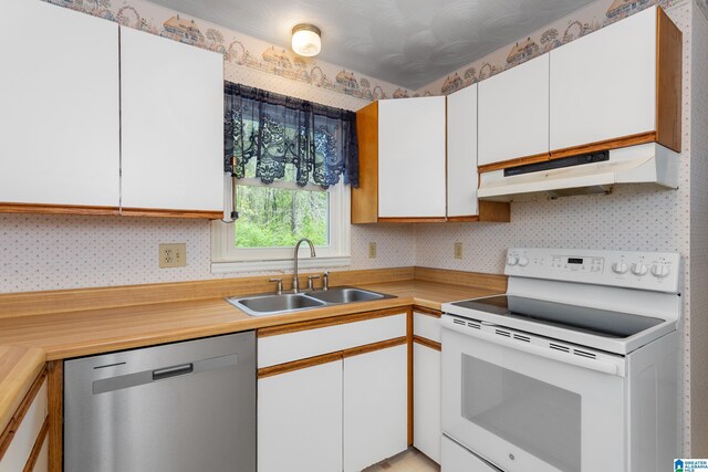 kitchen with dishwasher, a sink, electric stove, under cabinet range hood, and wallpapered walls