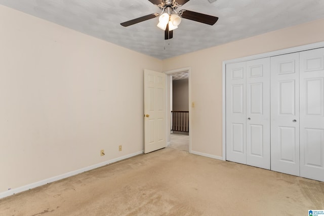 unfurnished bedroom with light carpet, baseboards, a closet, and a ceiling fan