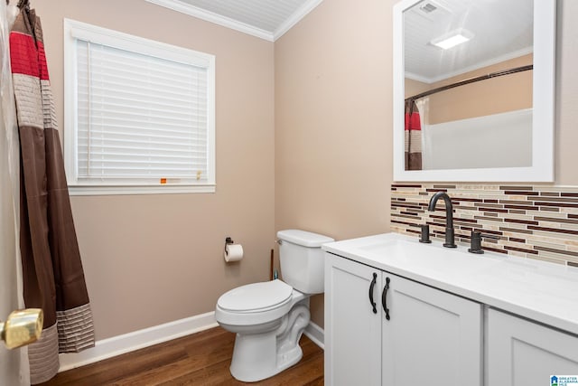 bathroom featuring vanity, baseboards, ornamental molding, decorative backsplash, and wood finished floors