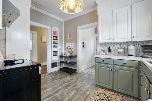 kitchen with light countertops, crown molding, black electric range, visible vents, and range hood