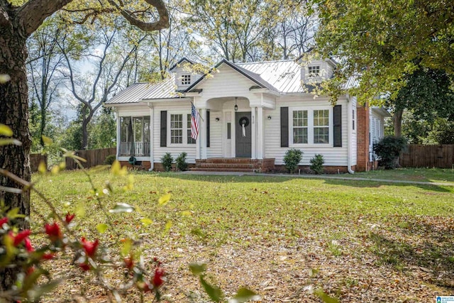 view of front of house featuring a front yard, fence, and metal roof