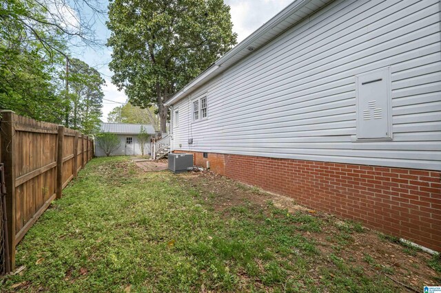 view of yard featuring central air condition unit and a fenced backyard