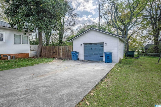 detached garage featuring concrete driveway and fence