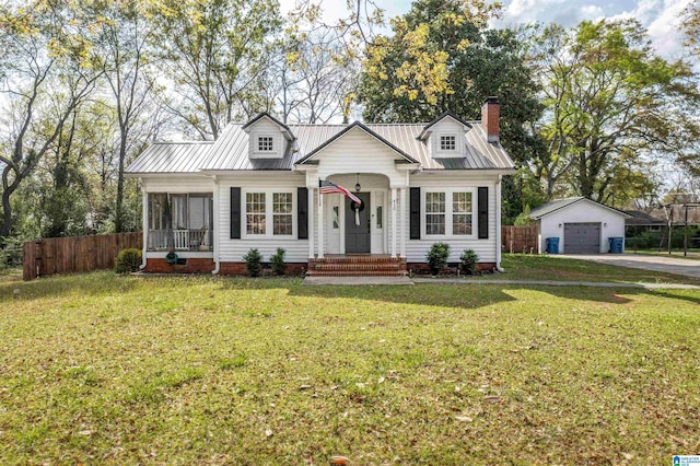 view of front of house featuring a front yard, a garage, an outdoor structure, fence, and driveway