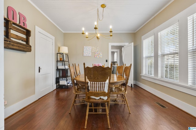 dining space featuring visible vents, an inviting chandelier, crown molding, and dark wood finished floors
