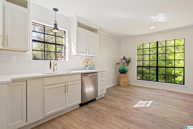 kitchen with light wood finished floors, dishwasher, a sink, and crown molding