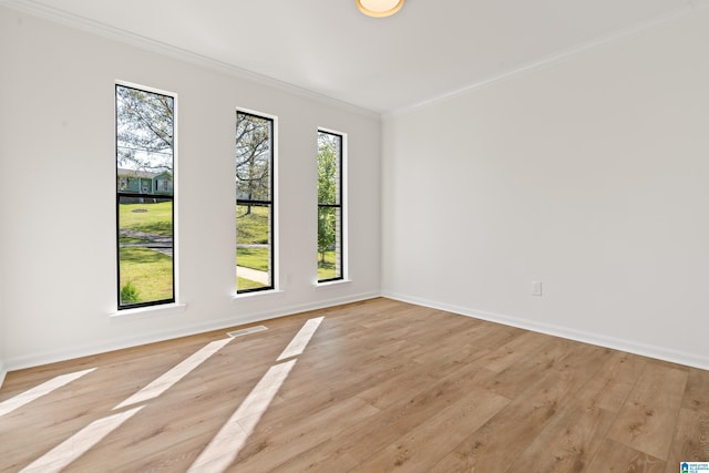 unfurnished room featuring light wood-style floors, visible vents, crown molding, and baseboards
