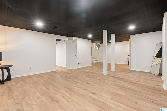finished basement with stairs, light wood-style flooring, baseboards, visible vents, and recessed lighting