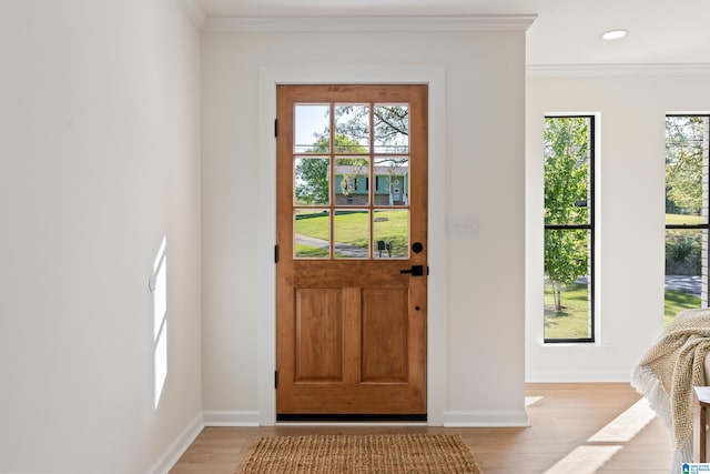 entryway with recessed lighting, baseboards, ornamental molding, and light wood-style flooring