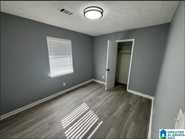 438 Henry St, Birmingham, AL 35214 - unfurnished bedroom with a closet, baseboards, a textured ceiling, visible vents, and wood finished floors