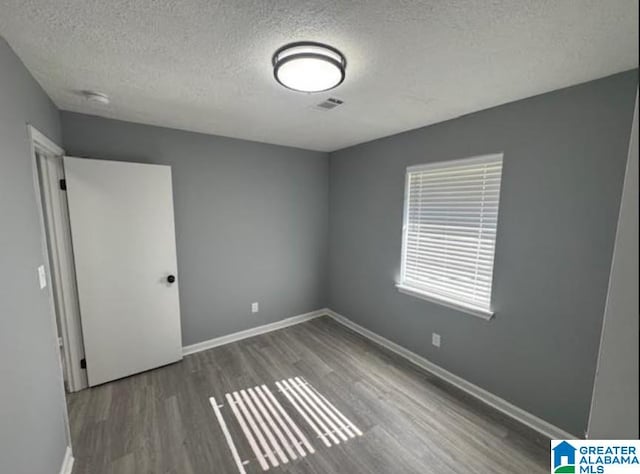 438 Henry St, Birmingham, AL 35214 - empty room with a textured ceiling, wood finished floors, baseboards, and visible vents