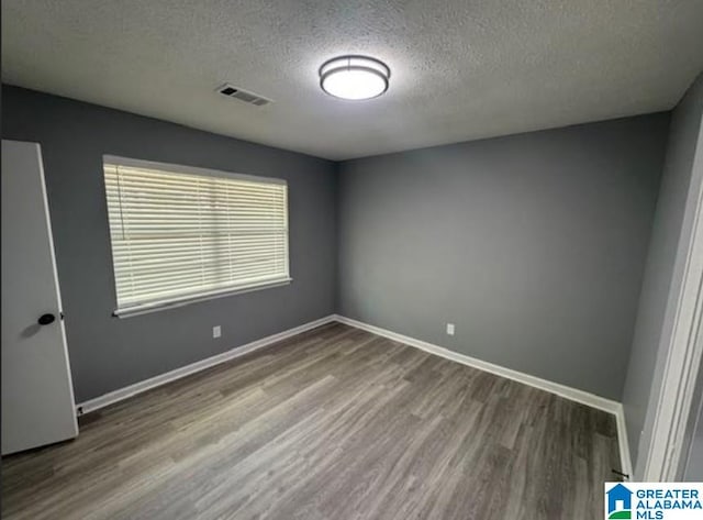 438 Henry St, Birmingham, AL 35214 - unfurnished room featuring visible vents, baseboards, wood finished floors, and a textured ceiling