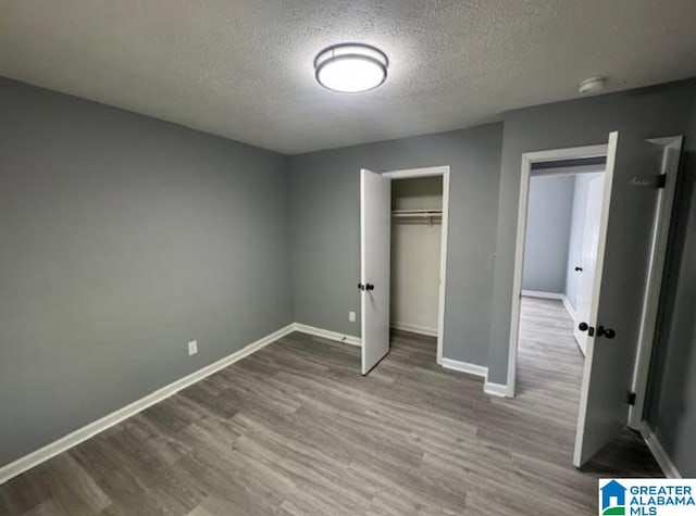 438 Henry St, Birmingham, AL 35214 - unfurnished bedroom with a textured ceiling, baseboards, and wood finished floors