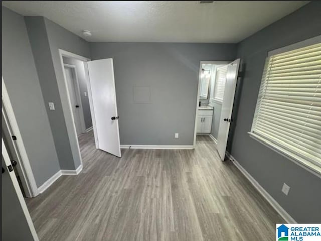 438 Henry St, Birmingham, AL 35214 - unfurnished bedroom with ensuite bath, baseboards, and wood finished floors