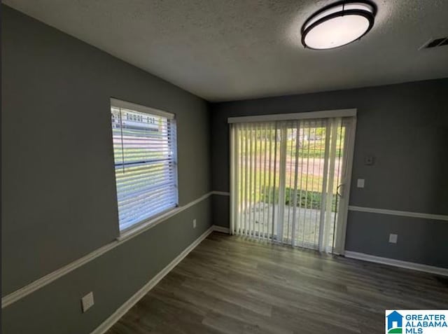438 Henry St, Birmingham, AL 35214 - empty room with visible vents, plenty of natural light, wood finished floors, and a textured ceiling