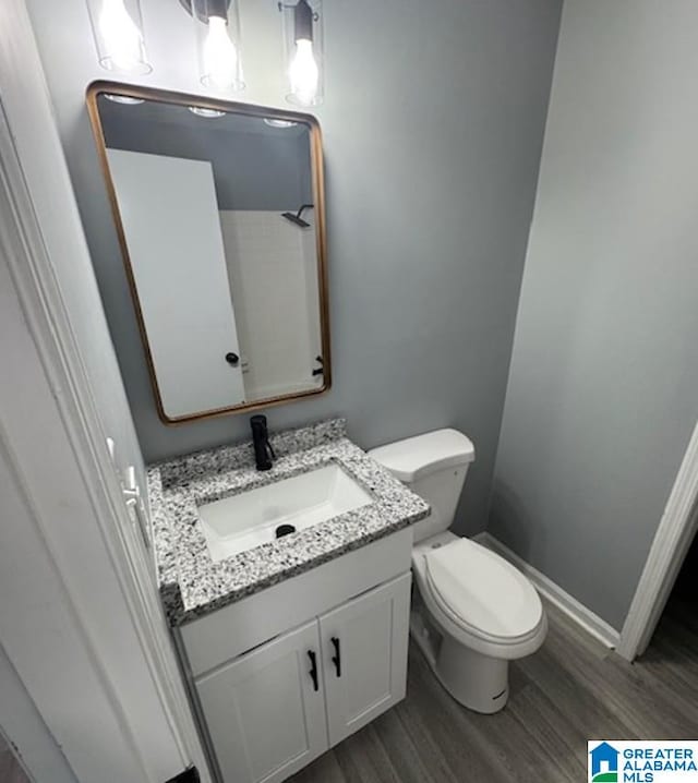 438 Henry St, Birmingham, AL 35214 - bathroom with toilet, wood finished floors, and vanity