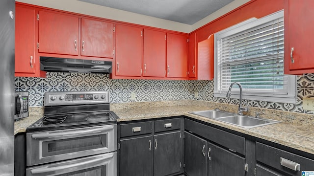 kitchen featuring light countertops, backsplash, under cabinet range hood, appliances with stainless steel finishes, and a sink