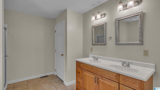 bathroom featuring double vanity, a sink, tile patterned flooring, and baseboards