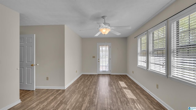 spare room with baseboards, a ceiling fan, and wood finished floors