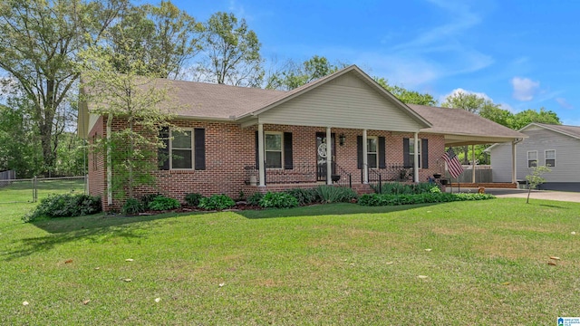 ranch-style house featuring a front yard, fence, an attached carport, and brick siding