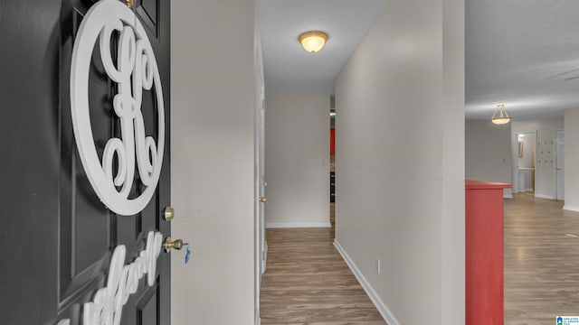 hallway with baseboards and wood finished floors