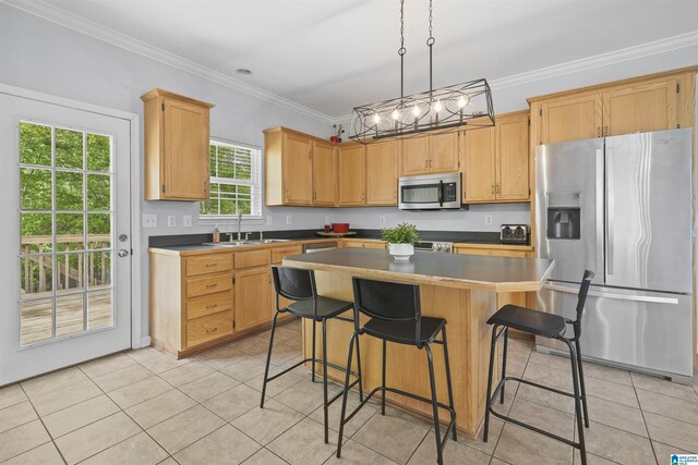 kitchen with a sink, light tile patterned floors, a center island, and appliances with stainless steel finishes