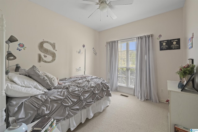 bedroom featuring light carpet, visible vents, baseboards, and ceiling fan