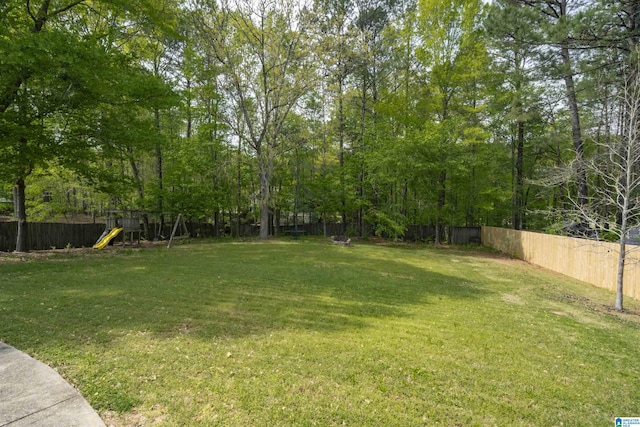 view of yard with fence and a playground