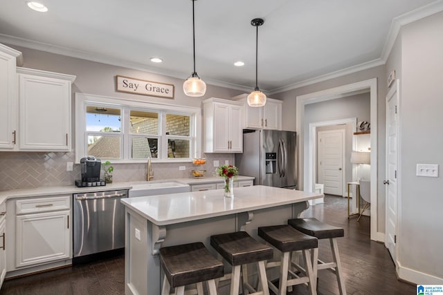 6037 Clubhouse Dr, Trussville, AL 35173 - kitchen featuring appliances with stainless steel finishes, ornamental molding, white cabinets, backsplash, and a kitchen breakfast bar