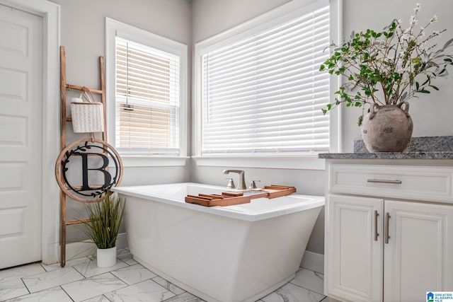 6037 Clubhouse Dr, Trussville, AL 35173 - bathroom featuring marble look tile flooring, a freestanding bath, and vanity