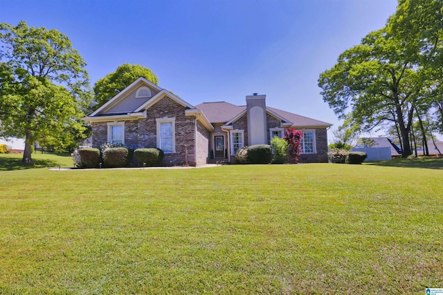 view of front of home featuring a chimney, a front yard, and brick siding