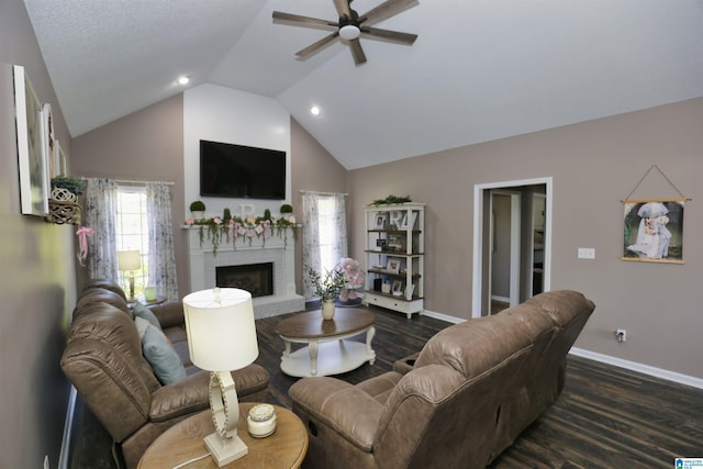 living room featuring baseboards, vaulted ceiling, a fireplace, ceiling fan, and wood finished floors