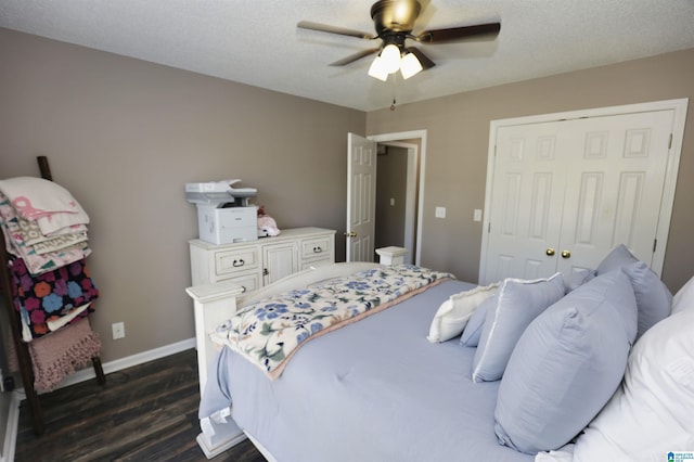 bedroom featuring ceiling fan, a textured ceiling, a closet, dark wood-style flooring, and baseboards