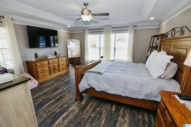 bedroom with a raised ceiling, crown molding, and dark wood-style floors