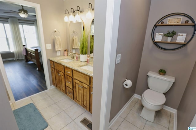 full bath featuring toilet, a sink, a ceiling fan, and visible vents