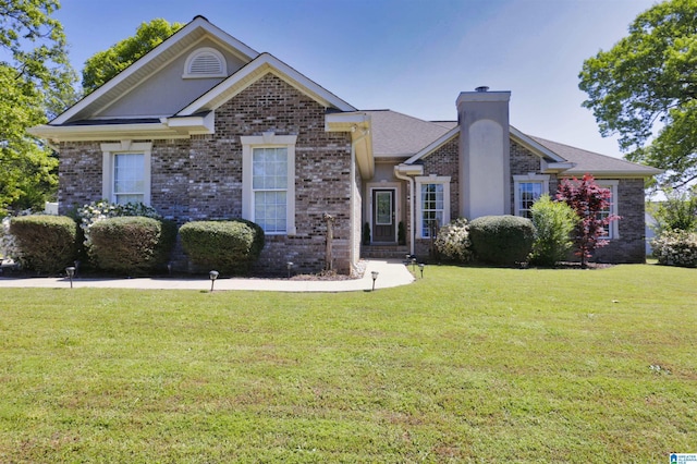 view of front of property with brick siding, a front yard, and a chimney