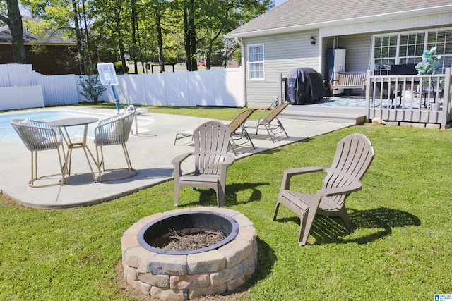 view of yard with a deck, an outdoor fire pit, fence, a patio, and a fenced in pool