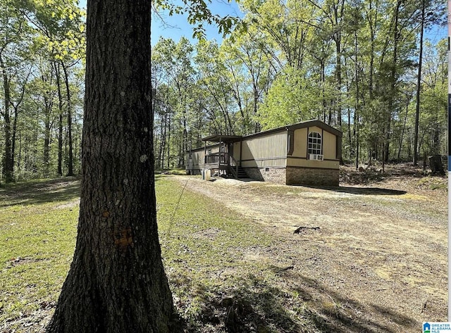 view of side of home with driveway and crawl space