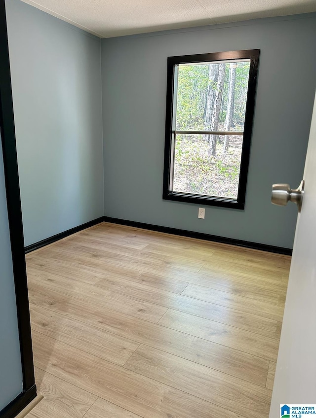 spare room featuring wood finished floors and baseboards