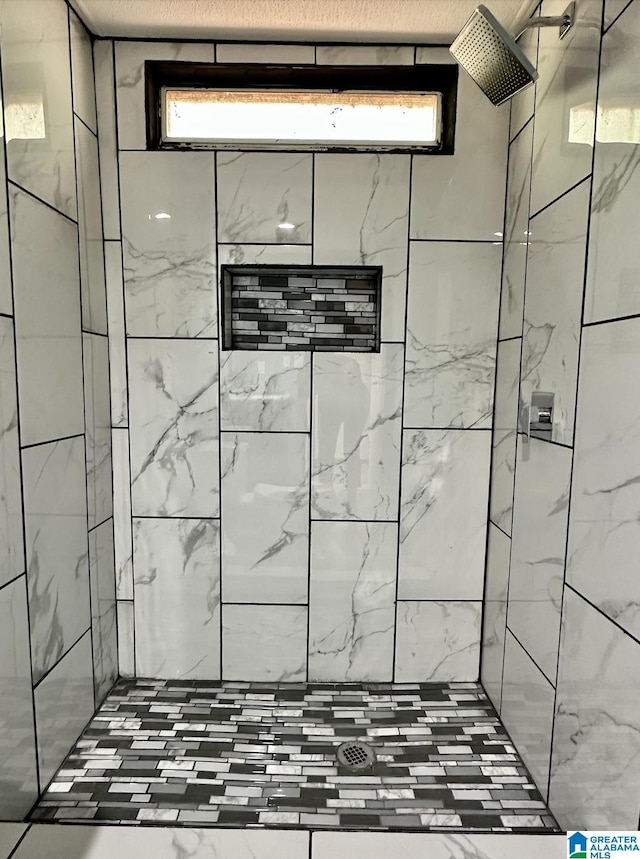 full bathroom with a tile shower and plenty of natural light