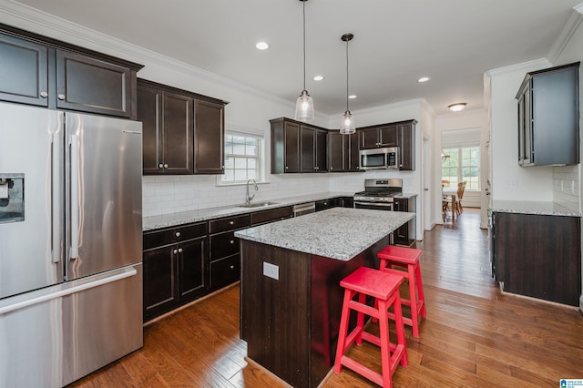 kitchen with plenty of natural light, a sink, appliances with stainless steel finishes, and a kitchen island